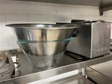 a large metal bowl sitting on a shelf in a kitchen