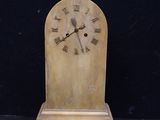 a small wooden clock with roman numerals on it