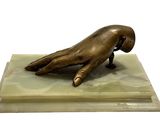 bronze statue of a hand resting on a marble base