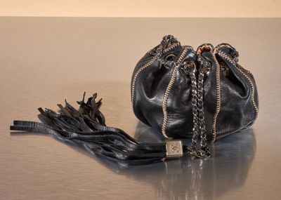 a black purse with a chain around it sitting on a table