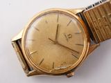 a gold watch that is sitting on a white surface