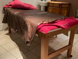 une table de massage recouverte d'une serviette, dans une pièce