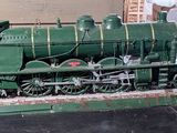 a model of a green train on display in a museum