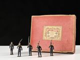 Des petits soldats sont posés devant un livre posé sur une table