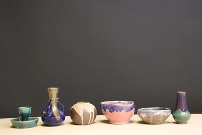 several vases and bowls are lined up on a table