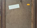 an old picture frame with a sticker on it sitting on top of a table