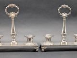 pair of silver plated candlesticks on stand on grey background