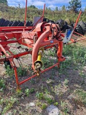 an image of a red farm equipment in a field