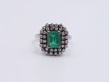 an emerald and diamond ring on a white background