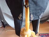 a black jacket on a wooden stand next to a rug