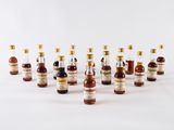 un ensemble de petites bouteilles d'alcool posées sur une surface blanche