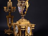 a gold and blue clock on a black table