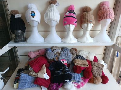 de nombreux chapeaux posés sur une étagère dans une pièce