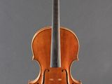 an old violin on a stand against a gray background