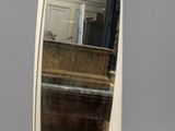 a white oval mirror sitting on a table
