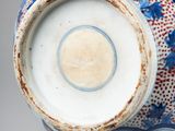 a blue and white vase with a red design on it