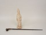 une petite statue représentant un homme tenant une canne