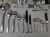 a lot of silver spoons and forks on the table