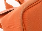 an orange bag with a tag on it sitting on a white surface