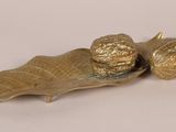 brass figurine of a snail and a leaf on a white background