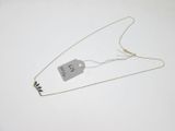 un collier auquel est attachée une étiquette sur une surface blanche