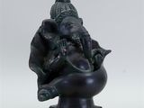 statue of an elephant sitting on a bowl with a bird on its back