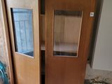 un meuble en bois avec une porte en verre au milieu d'une pièce
