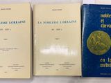 trois livres sont posés les uns à côté des autres sur une surface blanche