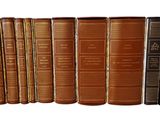 many books that are lined up together on a shelf