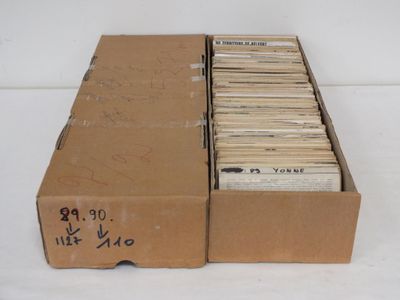 une boîte en carton remplie de vieux disques posée sur une surface blanche