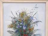 a painting of a bouquet of flowers on a red wall