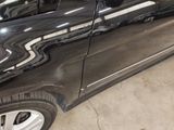 a black car parked in a garage with its door open