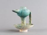 un petit vase bleu muni d'une anse, posé sur une table