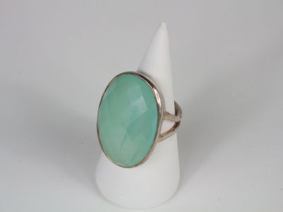 a close up of a ring with a green stone on it