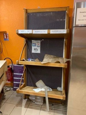 une cuisine aux murs orange et équipée d'un réfrigérateur en inox