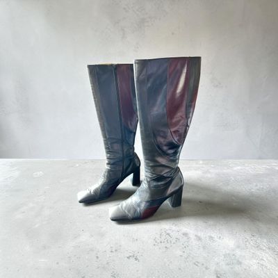une paire de bottes noires et argentées posées sur une surface blanche