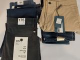 three pairs of men ' s pants sitting on top of a white table