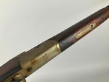 an old rifle with a wooden barrel and brass fittings