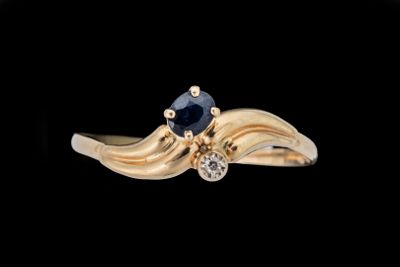 une image représentant une bague en or sertie d'un saphir et d'un diamant