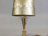 lampe de table en feuille d'or avec un abat-jour doré sur fond blanc