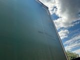 a truck that is driving down the road under a cloudy sky