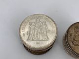 two silver coins sitting next to each other on a white surface