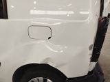 a white van that has been dented and is parked in a garage