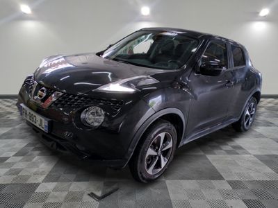 the black nissan juke suv is parked in a large room