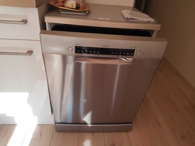 a dishwasher in the corner of a small kitchen