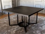 une table noire avec un piètement en métal dans une pièce