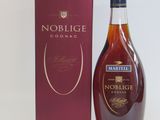 the bottle of nobilge cognac is next to the box