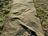 un sac de couchage posé par terre, dans l'herbe