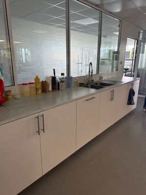 une cuisine avec un évier et un plan de travail sur lequel sont posées de nombreuses bouteilles