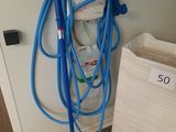 a blue hose attached to a wall next to a white bag